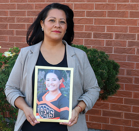Rosa holding a picture of her daugther, Jazmyne, a donor hero.